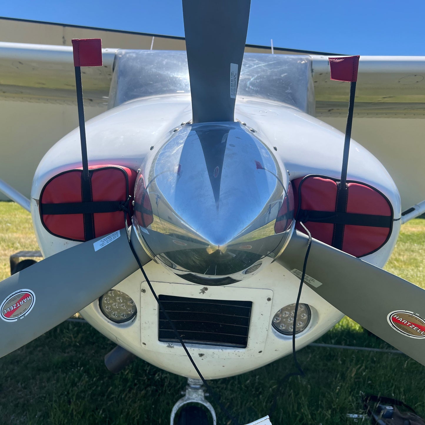White Cessna C182 close up of nose with red cowl plugs