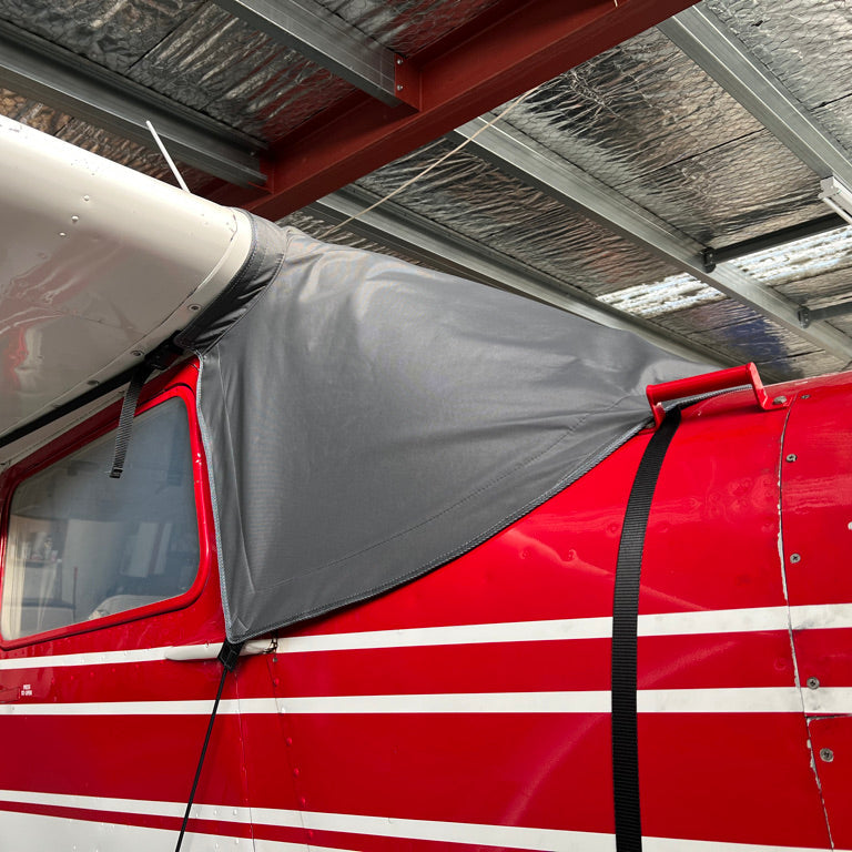 Red-Cessna-180-in-hangar-with-windscreen-cover