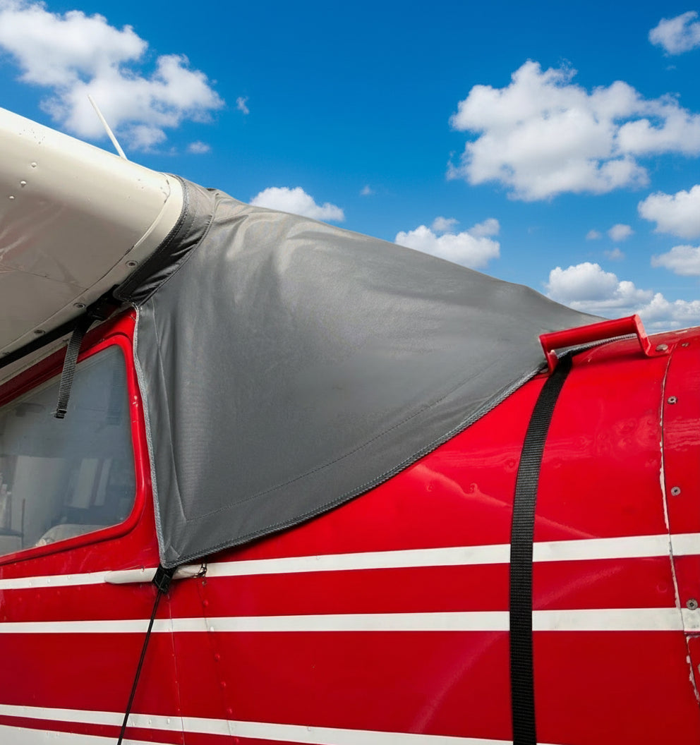 red-cessna-180-with-aerosew-grey-windscreen-cover-blue-sky-with-clouds-background