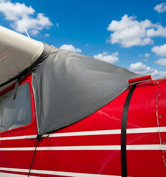 red-cessna-180-with-aerosew-grey-windscreen-cover-blue-sky-with-clouds-background
