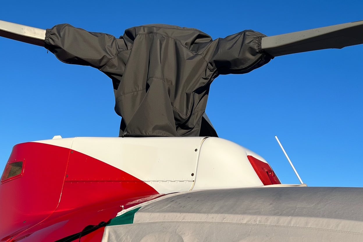 Close-up of charcoal rotor head cover fitted around the main rotor blade roots on a Squirrel AS350 helicopter