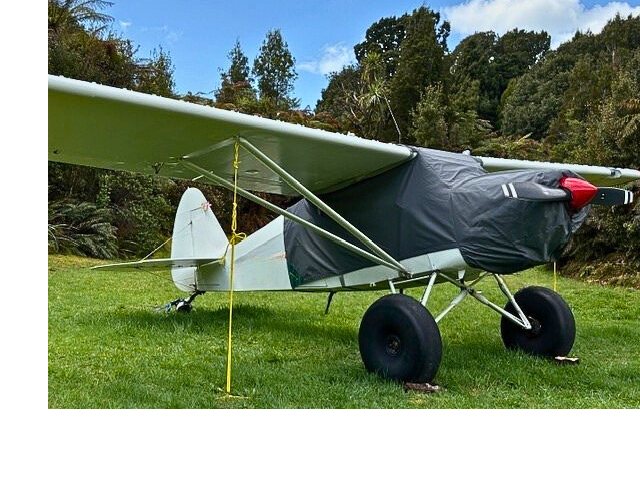 cream-piper-pacer-with-aeriosew-cover-in-bush-with-building-behind