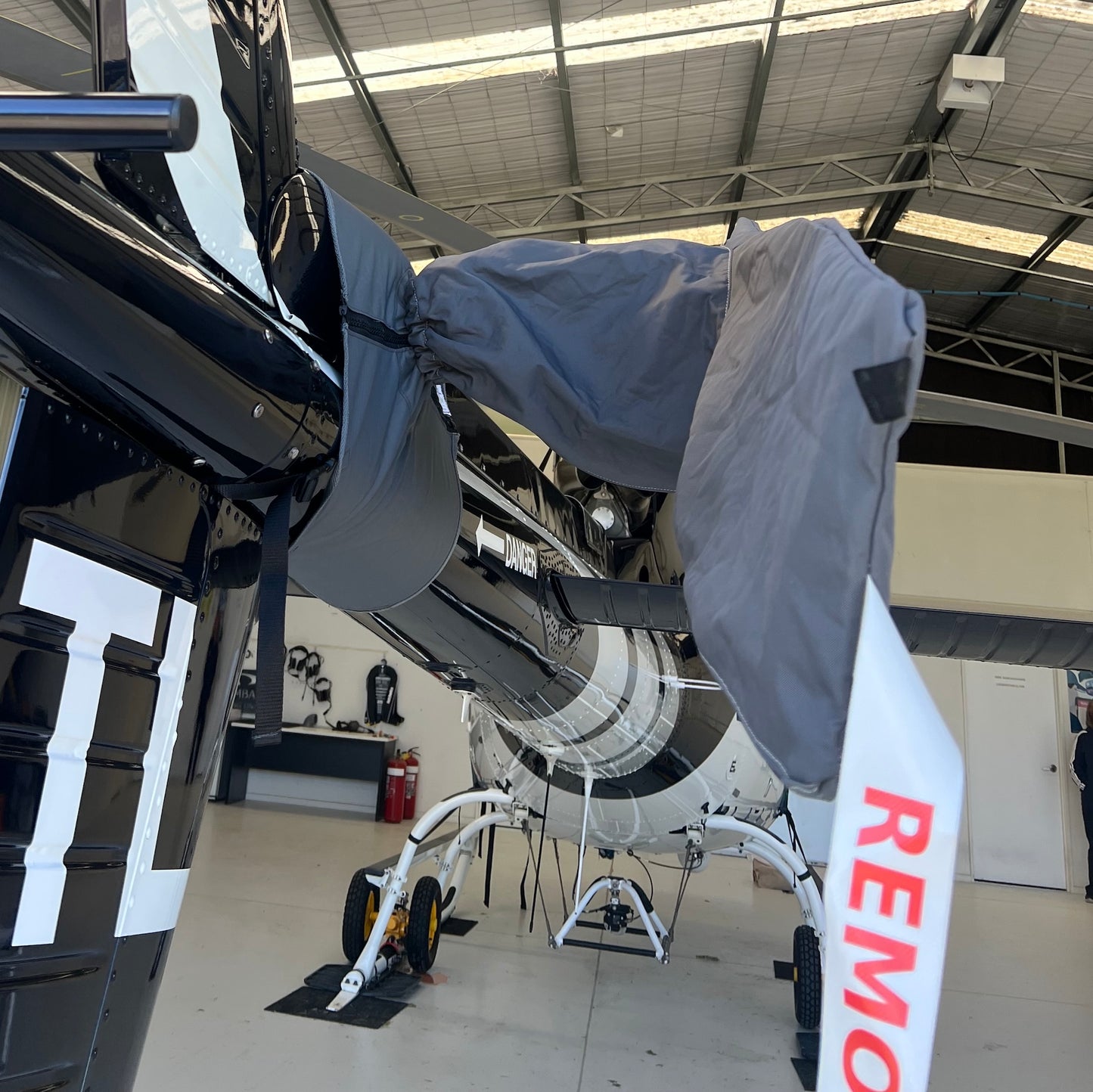 Charcoal Aerosew tail rotor cover fitted to a white AS350 helicopter, protecting the hub and blade-root area.