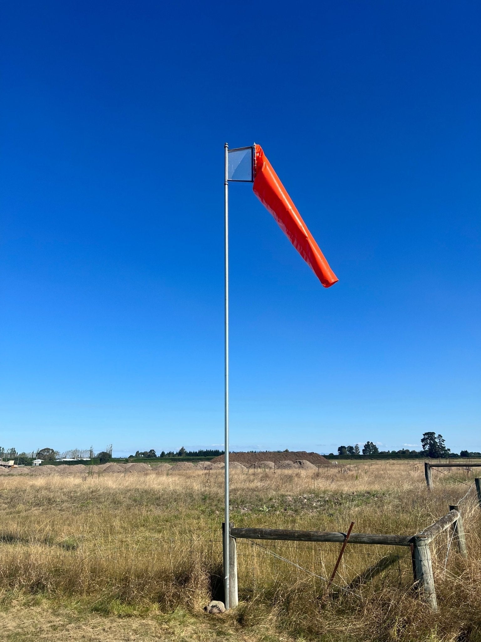 windsock-in-paddock-with-piles-of-shingle-behind