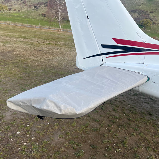 Light-grey aerosew horizontal tailplane and elevator cover fitted to one side of a white Cessna 172 aircraft