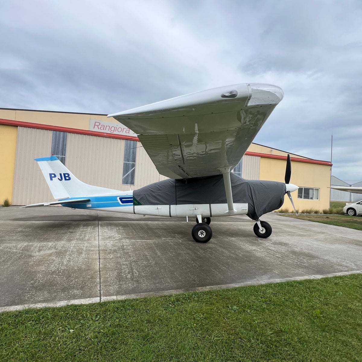 Full side view of a Cessna C206 showing the tailored charcoal Aerosew canopy cover fitted beneath the high wing.