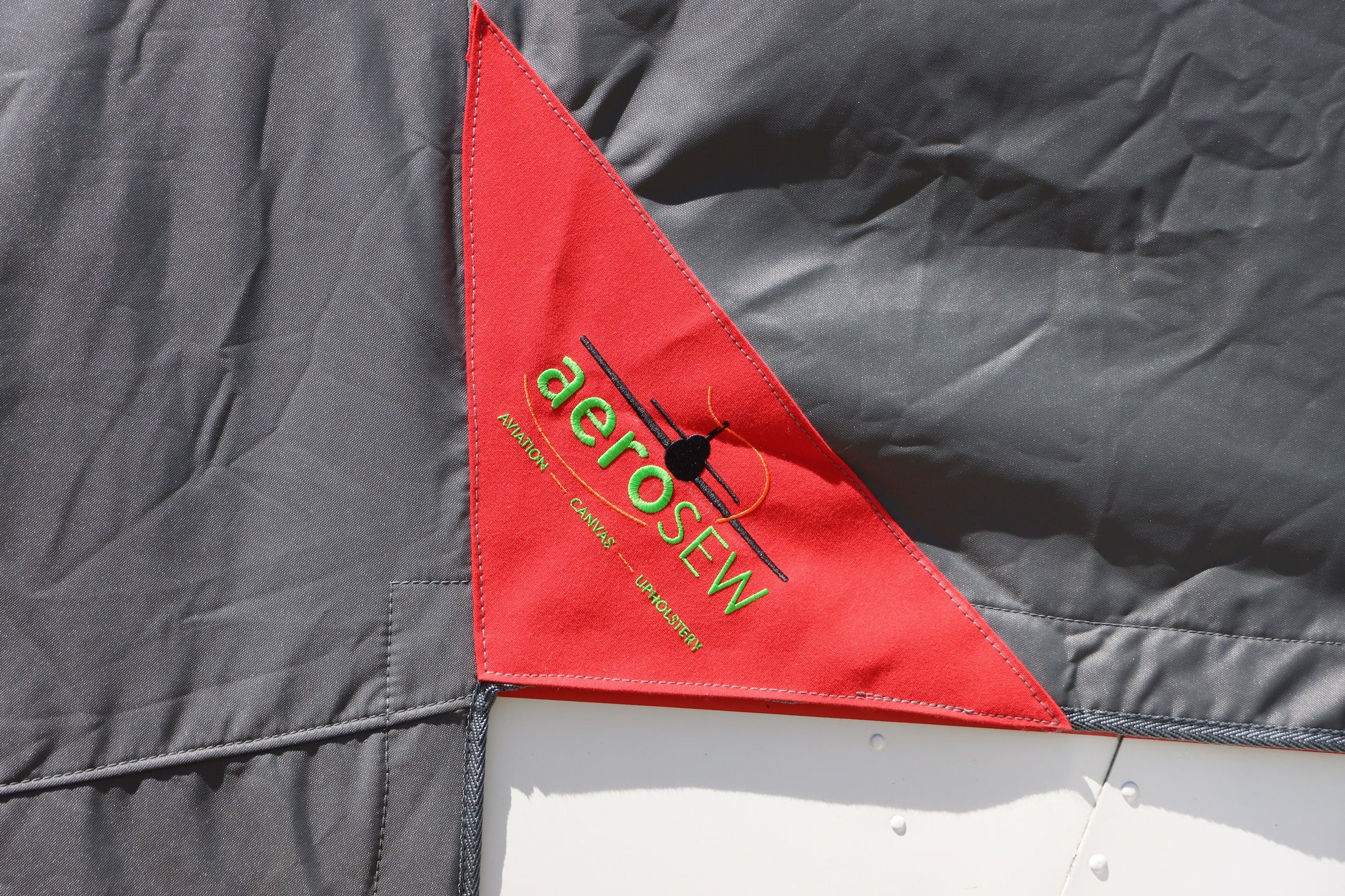 Red-triangle-with-'aerosew'-logo-on-a gray-background.jpg